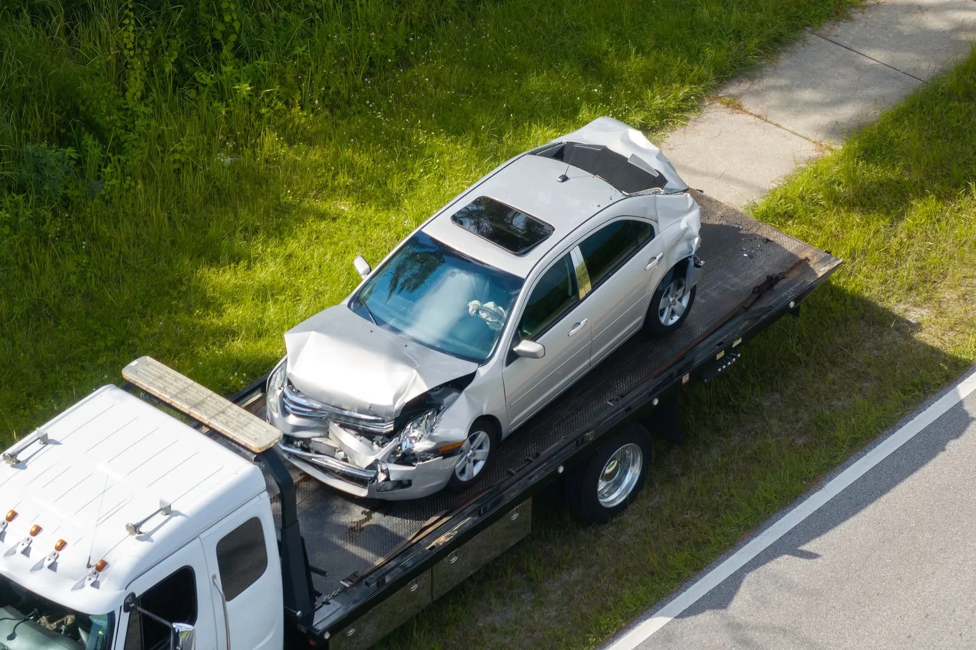 Crushed sedan on a flatbed